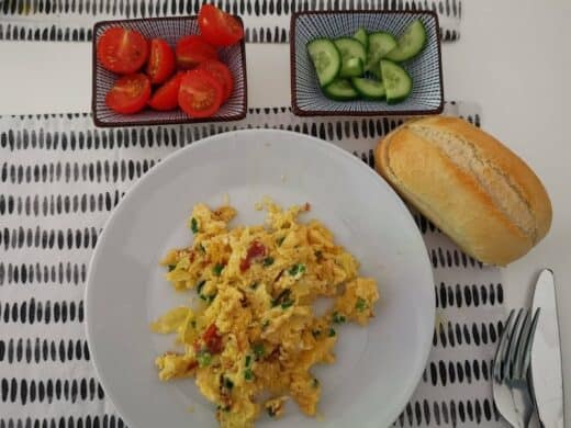 Rührei, Tomaten, Gurken und Brötchen