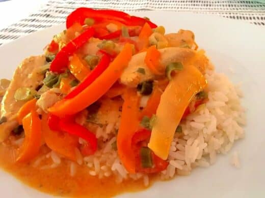 Thai Curry von Nic auf dem Teller (Reis, Paprika rot und orange, Frühlingszwiebeln, Hühnchen)
