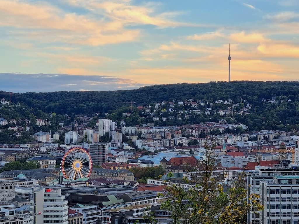 Blick in den Sonnenuntergang über Stuttgart - mit Riesenrad vor dem neuen Schloss und Fernsehturm