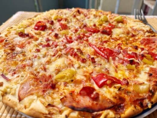 Pizza mit Schinken, Peperoni und Käse aus der Gefriertruhe