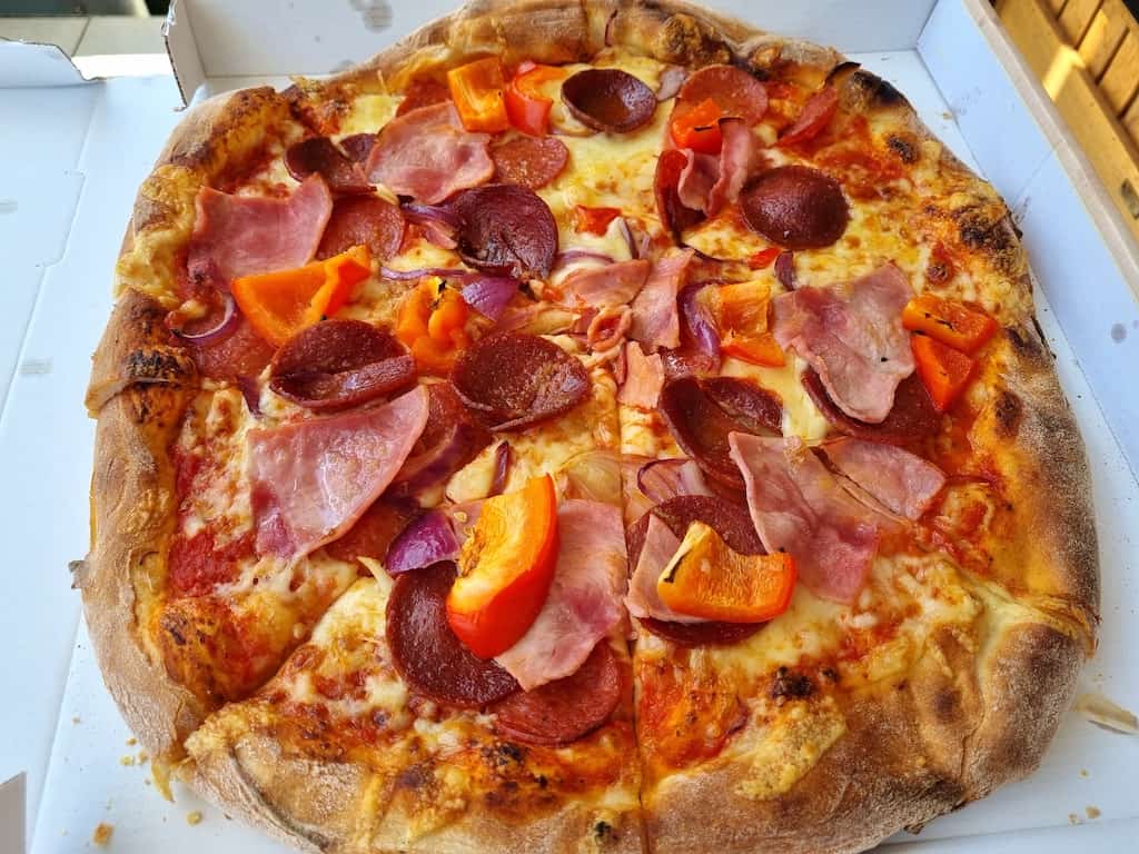 Pizza von Angelos: Salami, Schinken, Sucuk, rote Paprika, rote Zwiebeln und Knoblauch