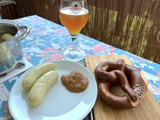 Weißwurstfrühstück mit zwei Weißwürsten, süßem Senf, einer Brezel und einem Bier