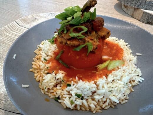 Mit Hackfleisch gefüllte Paprika auf Reis und Tomatensoße