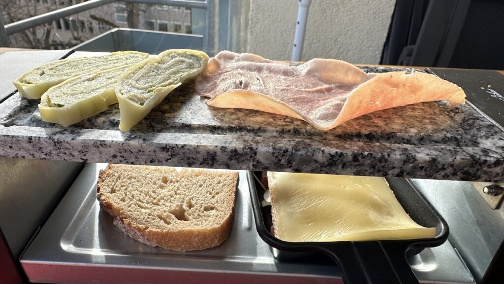 Raclette mit Brot, Maultaschen, Schinken (und Speck und Zwiebeln unter dem Käse)