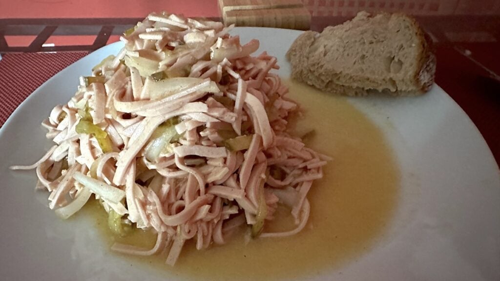 Wurstsalat mit Essiggurken und Brot