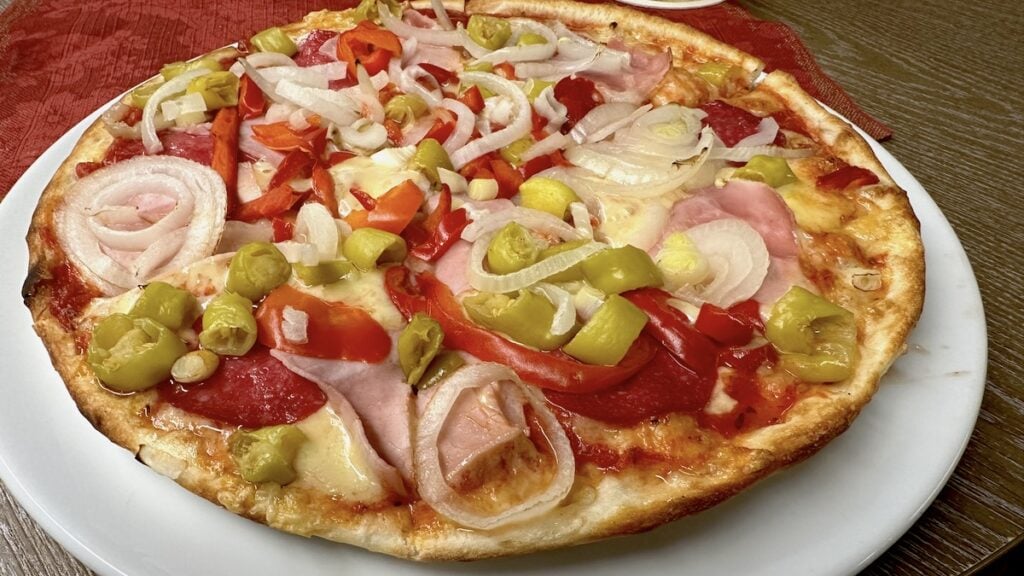 Pizza mit Salami, Schinken, Paprika, Zwiebeln und Peperoni