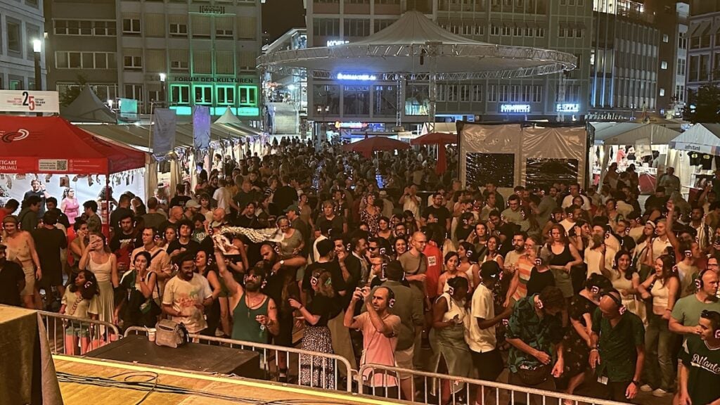 Blick von der Bühne auf den Marktplatz auf die tanzenden Menschen mit Kopfhörern bei der Silent Disco