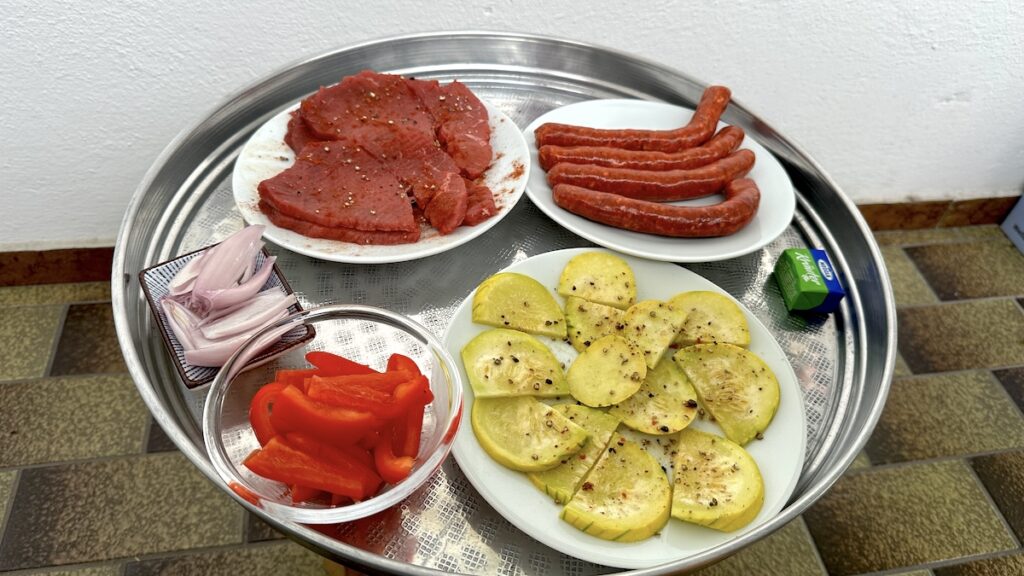 Minutensteaks, Merguez, Zucchini-Kürbis, Paprika und Zwiebeln zum Grillen bereit