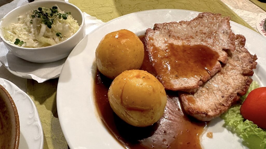 Schnitzel natur mit Knödeln und Hopfen-Biersauce, dazu Krautsalat 