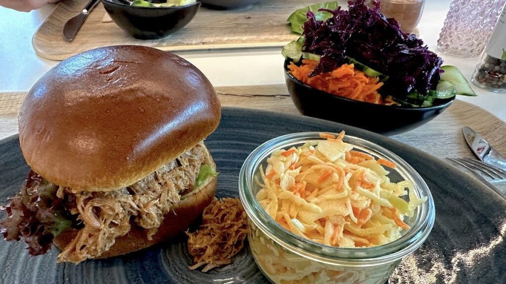 Pulled Pork Burger mit Farmersalat und zusätzlichem Beilagensalat im Betriebsrestaurant