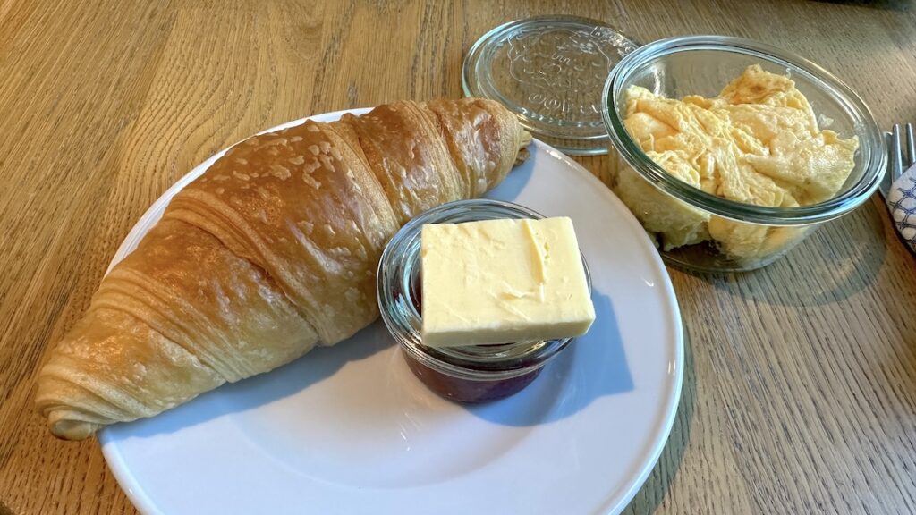 Croissant, Butter, Marmelade sowie Rührei im Glas