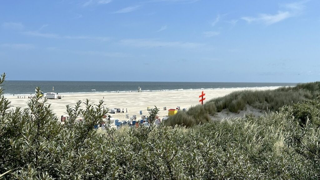 Blick von der Strandhalle über die Dünen auf Strand und Meer