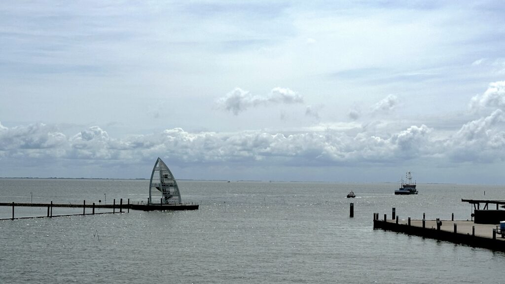 Es geht raus aus dem Juister Hafen, links das Seezeichen in Form eines Segels