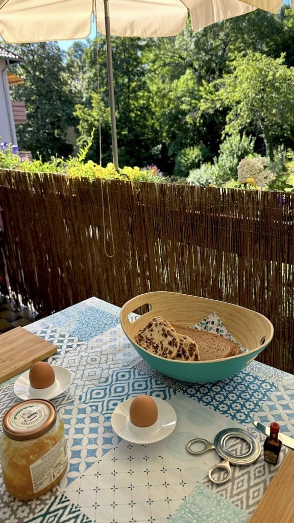 Balkonfrühstück mit gekochtem Ei, Brot und von Juist mitgebrachten Rosinenstuten