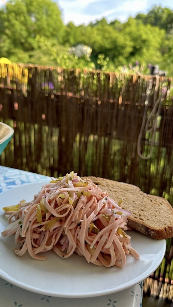 Wurstsalat mit Brot auf dem Balkon