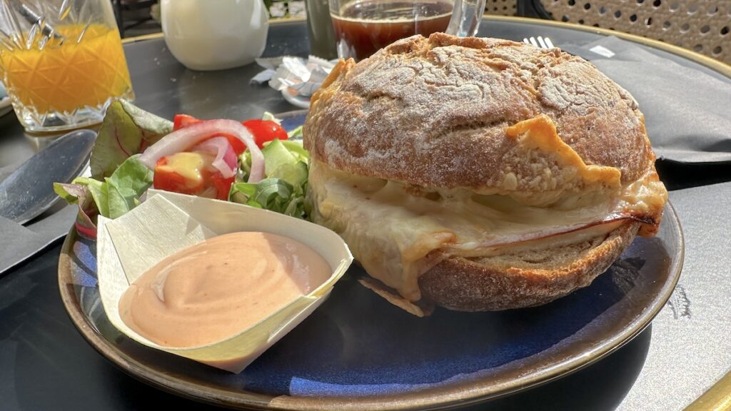 Mit Schinken und Käse überbackenes Brötchen im "Le Bar"