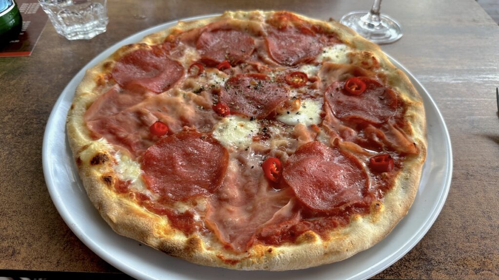 Pizza mit Schinken. Salami und Chili