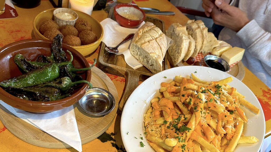 Brot mit Aioli, Pommes mit Käsessoße und Parmesan, Bitterballen, Piementos und eine Käseplatte