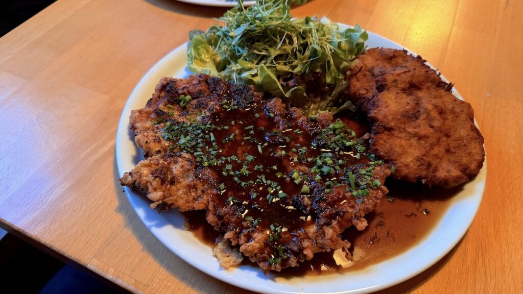 Schnitzel "Bayern", (mit Meerrettich und süßem Senf in der Panade, dazu eine Dunkelbiersoße und dazu Brezenröstis)