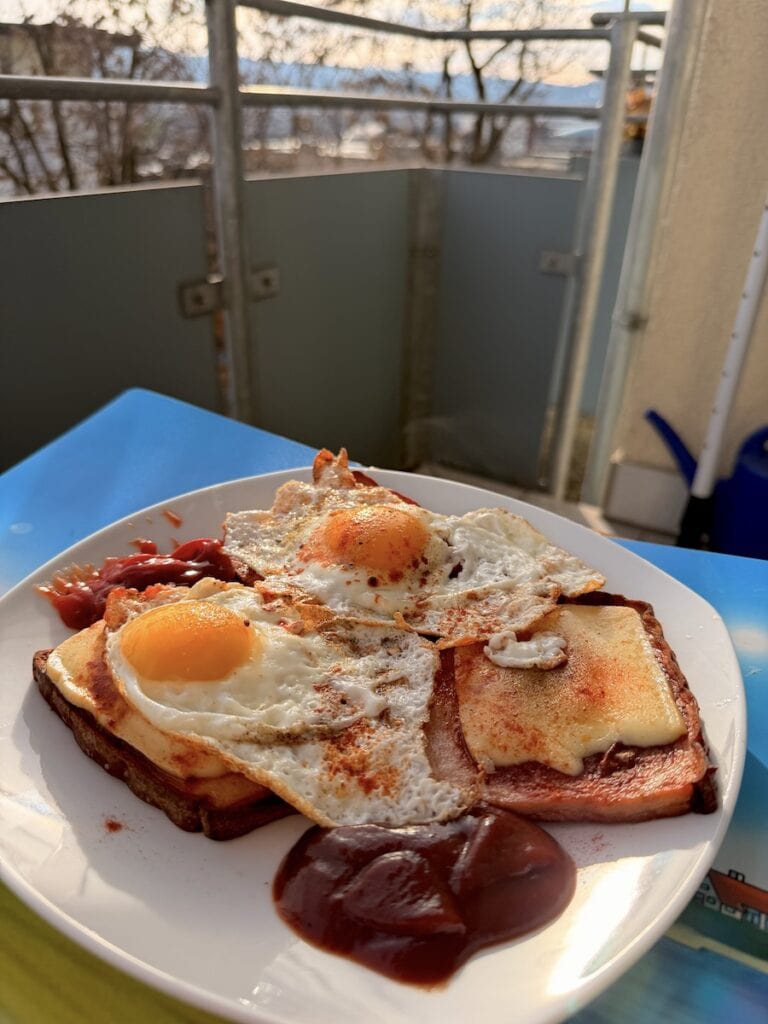 Angbratener Fleischkäse mit Raclettekäse drauf und Spiegeleier