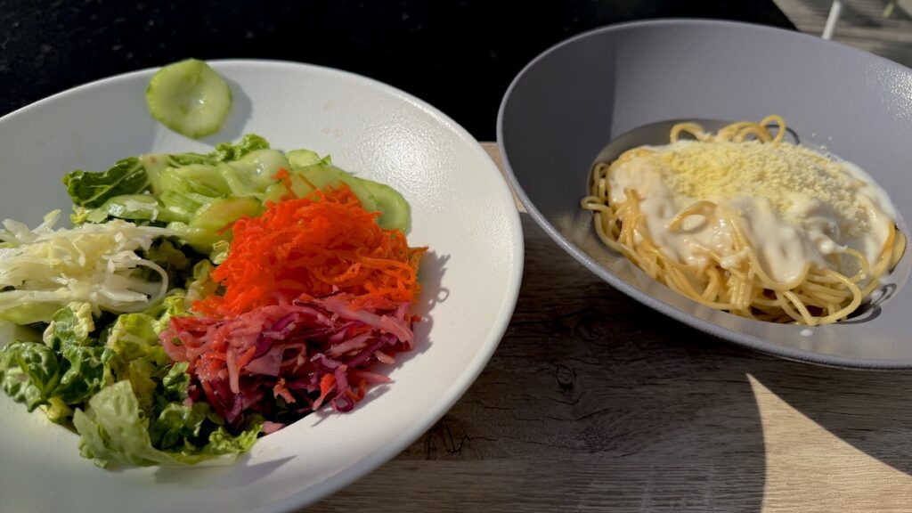 Spaghetti Gorgonzola mit Beilagensalat vom Büfett im Betriebsrestaurant draußen in der Sonne