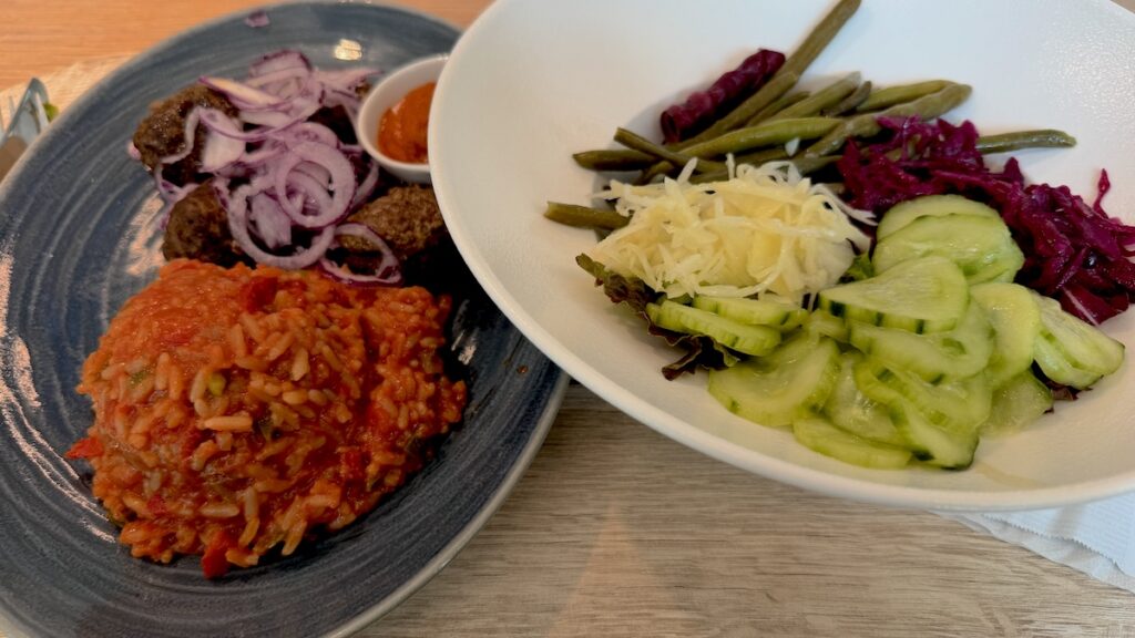 Seltsam geformte Cevapcici mit Tomatenreis und Salat vom Büfett